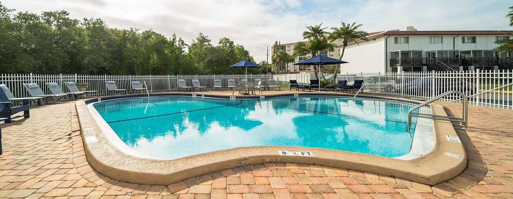 a pool with chairs and umbrellas by it