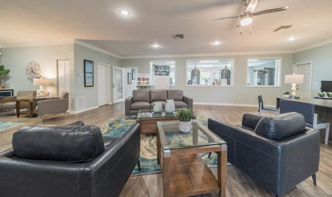 a clubroom with a couch, tables and chairs